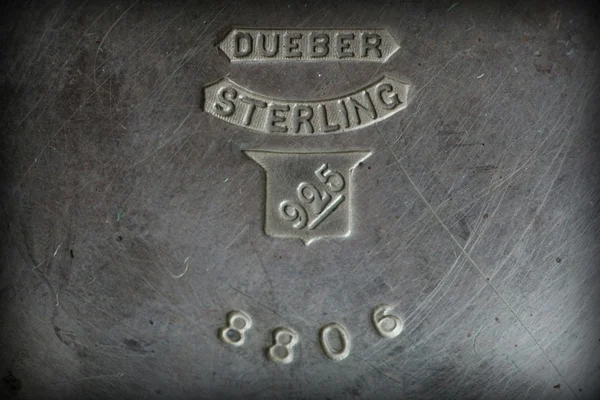 Close-up of Dueber Sterling 925 hallmarks on a tarnished silver surface.
