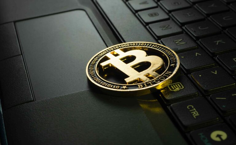 A bitcoin on a laptop.